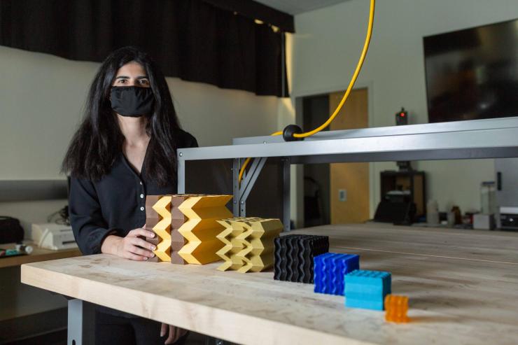 <p>Larissa Novelino, a Ph.D. student at Georgia Tech, shows several metamaterial prototypes at different scales. (Credit: Allison Carter, Georgia Tech)</p>