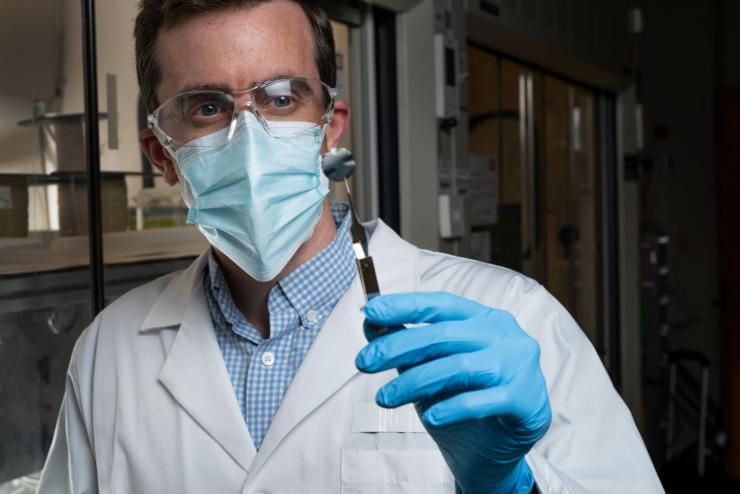 <p>Georgia Tech Associate Professor Ryan Lively holding a small sample used to experimentally understand how the xylenes transport through the carbon structure. (Photo credit: Christopher Moore, Georgia Tech)</p>