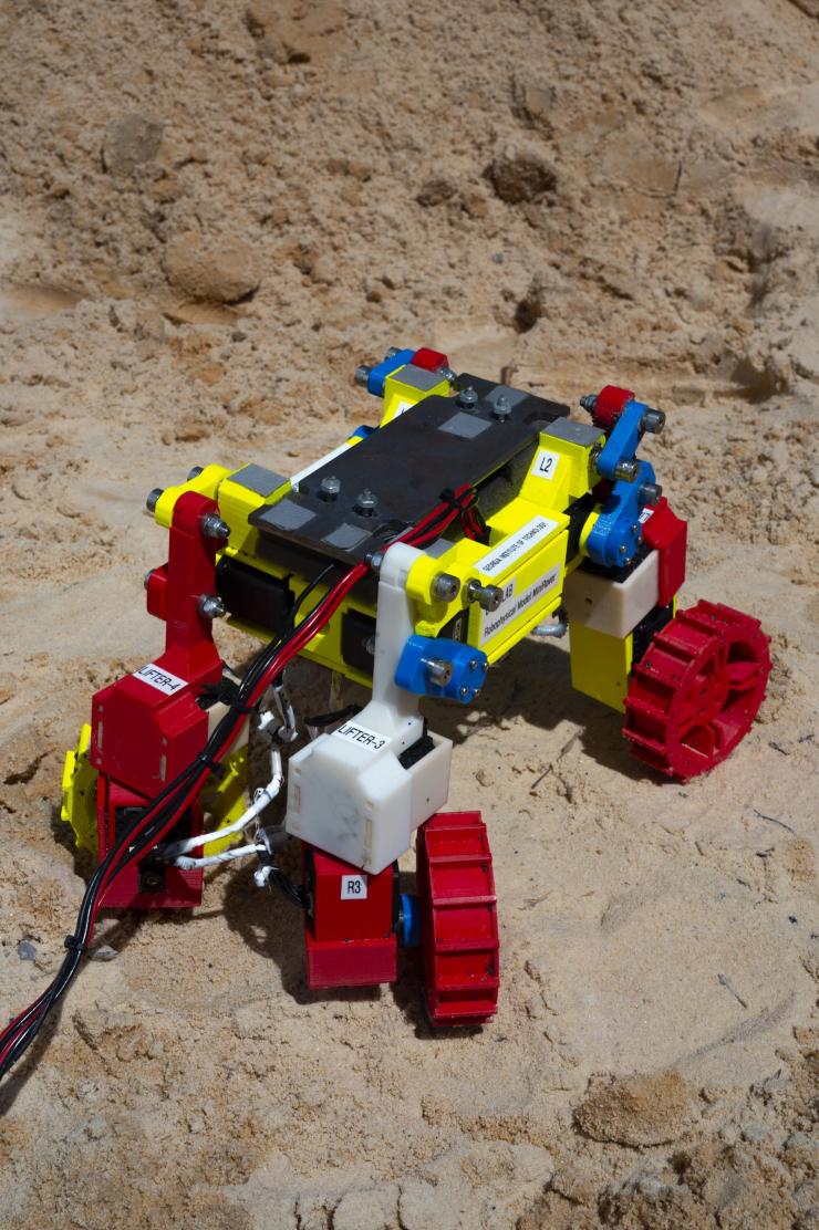 <p>Built with multifunctional appendages able to spin wheels that can also be wiggled and lifted, the Mini Rover was modeled on a novel NASA rover design and used in the laboratory to develop and test complex locomotion techniques robust enough to help it climb hills composed of granular material, here ordinary beach sand. (Credit: Christopher Moore, Georgia Tech)</p>